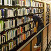 Un usuario buscando un libro delante de una estantería